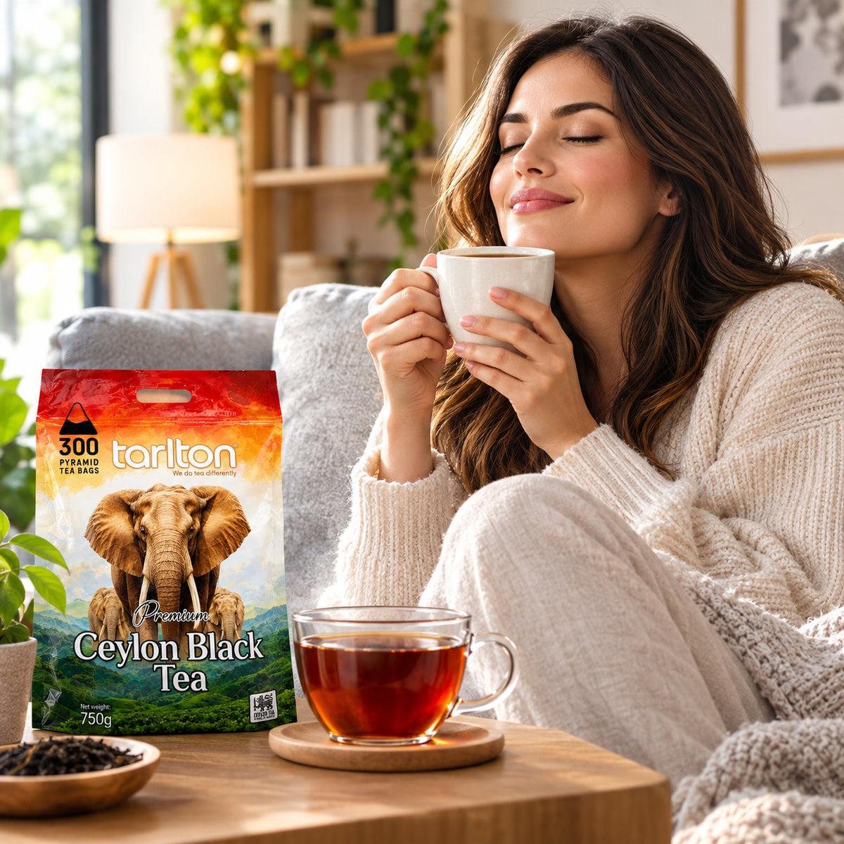 Frau genießt eine Tasse Tarlton Ceylon Black Tea gemütlich im Wohnzimmer